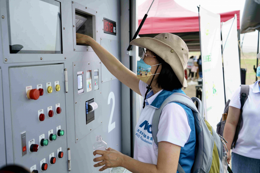 志工們將拾起的寶特瓶投入「好歸塑專車」，讓廢棄塑料空瓶可以直接粉碎、縮小體積，未來將可再製成購物袋、寶特衣、悠遊卡等生活用品